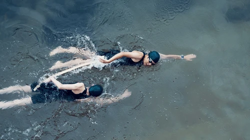 Female triathletes swimming in the ocean