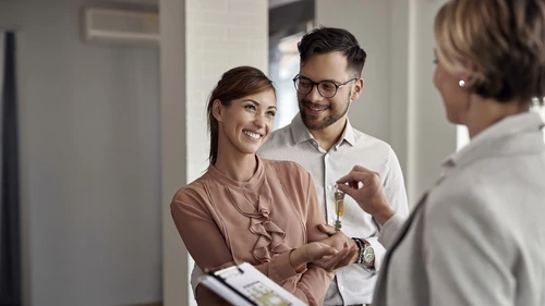 Young couple getting keys to new home