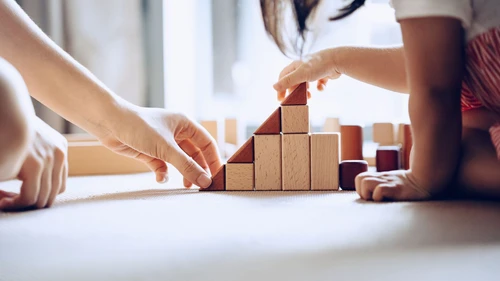 Mother and daughter playing with wooden blocks
