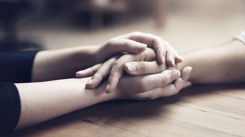 Holding hands at wood table