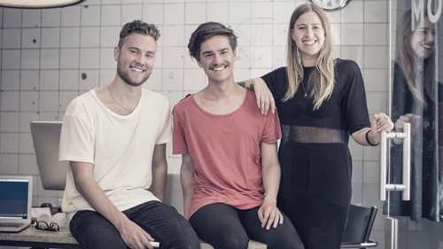 Three young and smiling people looking at camera 