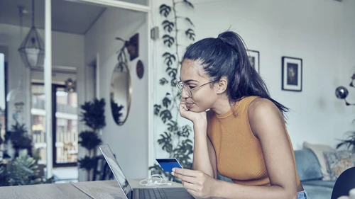 Young woman sitting at a desk and watching her laptop