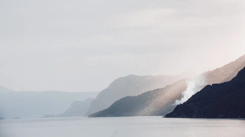 Scenic view of sea and mountains against sky