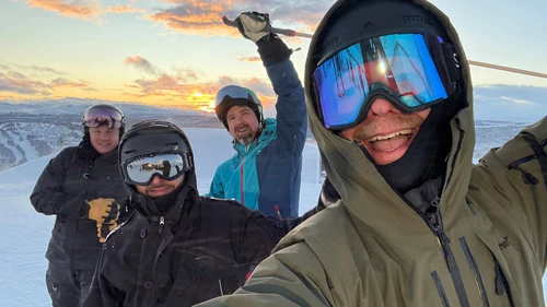 Four guys on a mountain with skis