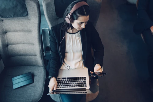 Kvinde i tog med computer og telefon