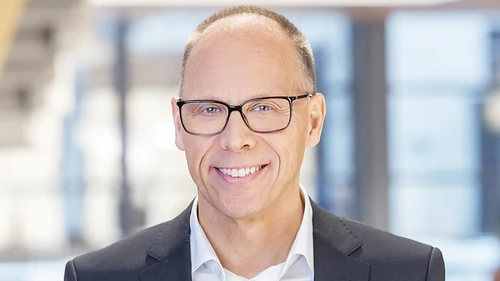 Man in glasses  smiling and looking into the camera. 