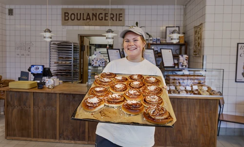 Bagare står med plåt med bullar. 