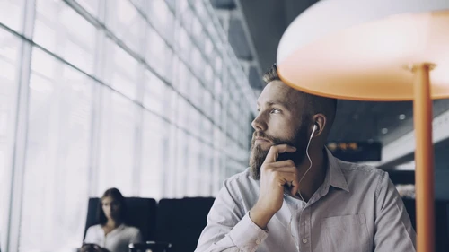 thoughtful-businessman-looking-away-while-sitting-at-airport-