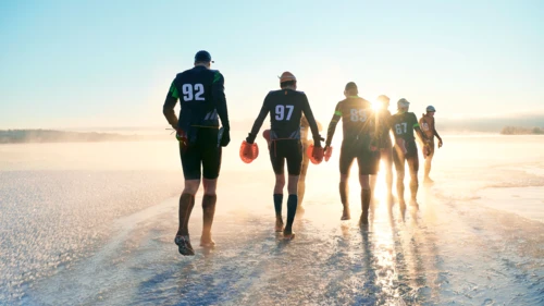 group_of_swimmers-walking-towards-sunrise-on-ice