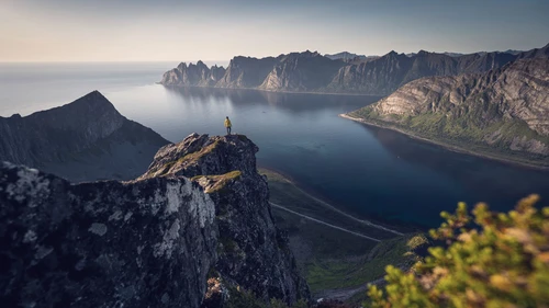 Woman stands on top of Husfjellet in Senja Island in summer season Norway