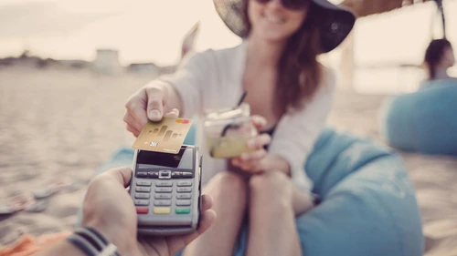 Woman on a beach paying with credit card