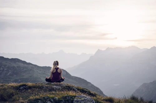 Woman doing yoga on mountain top
