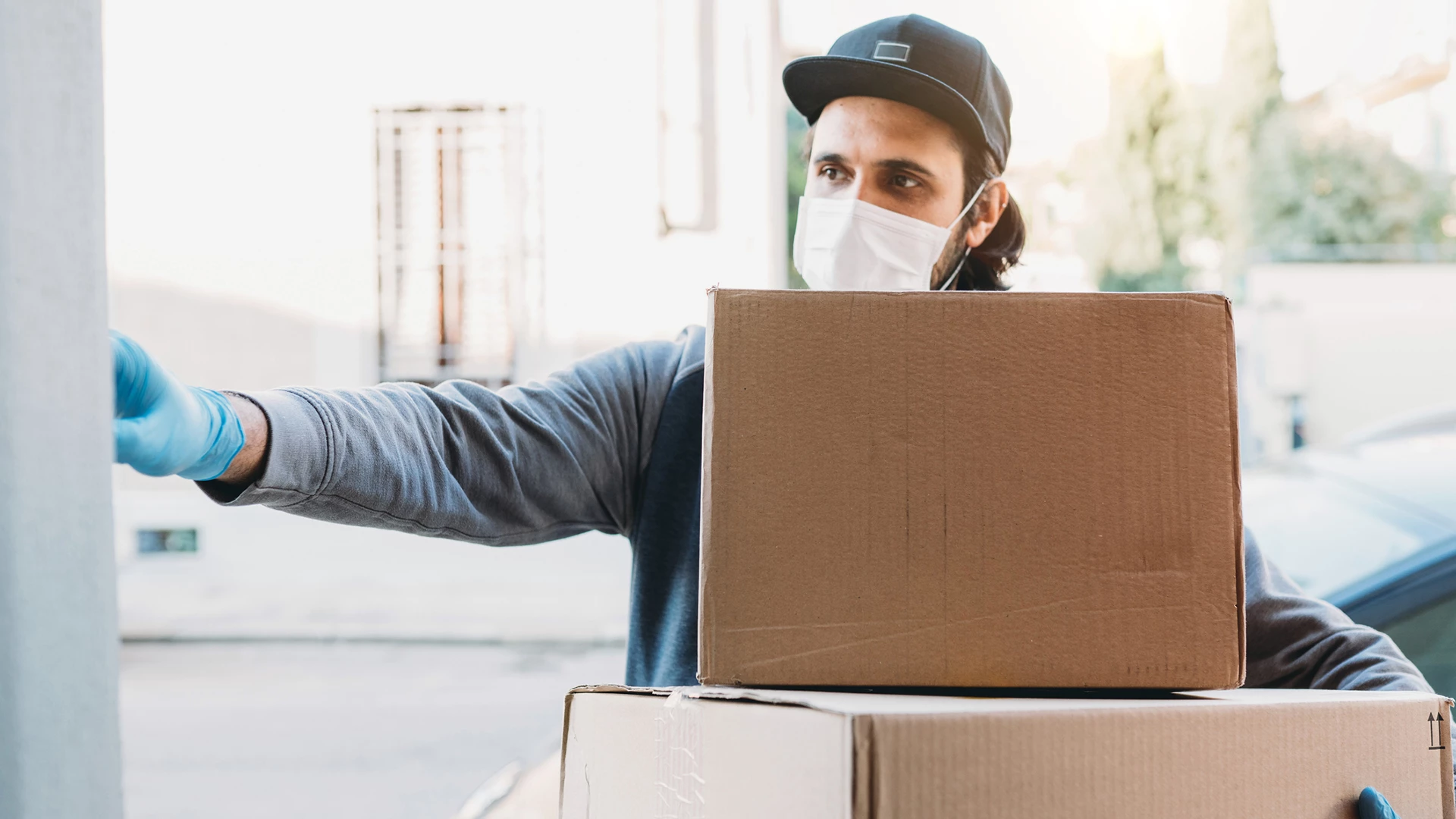 Delivery man is ringing the bell to deliver two cardboard boxes