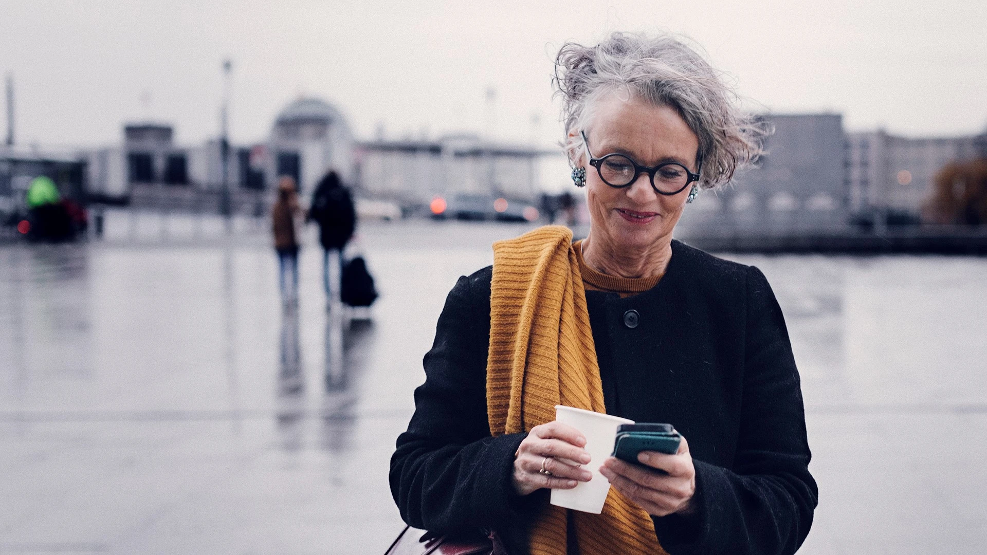 Senior woman outside smiling at phone