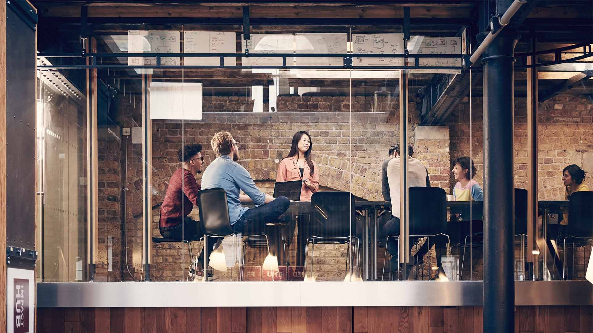 Group of people having a business meeting in modern office with brick walls
