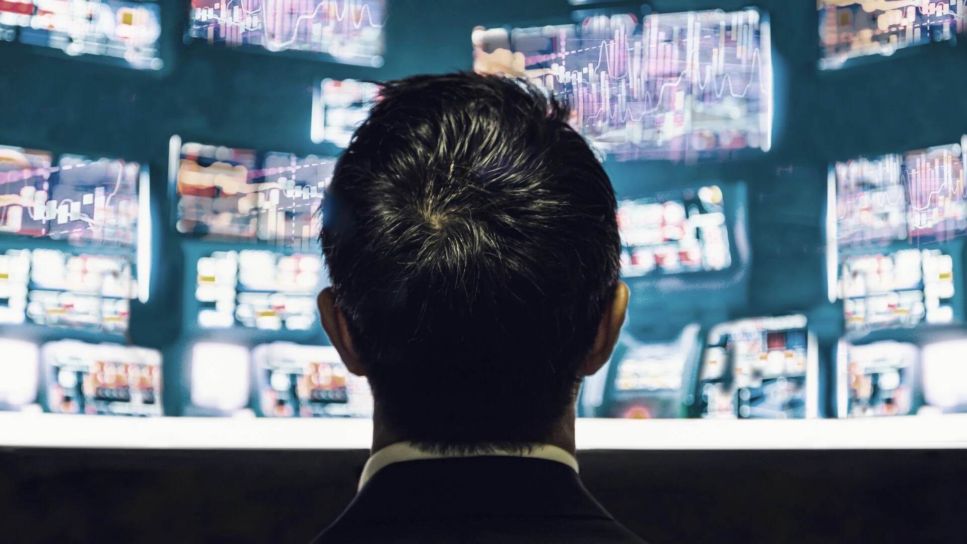 businessman-trader-looking-at-monitor-with-stock-exchange-graph