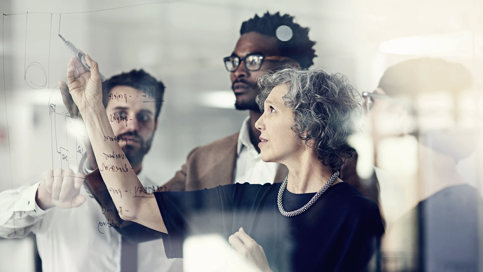 Colleagues-in-front-of-glass-wall_1920x1080