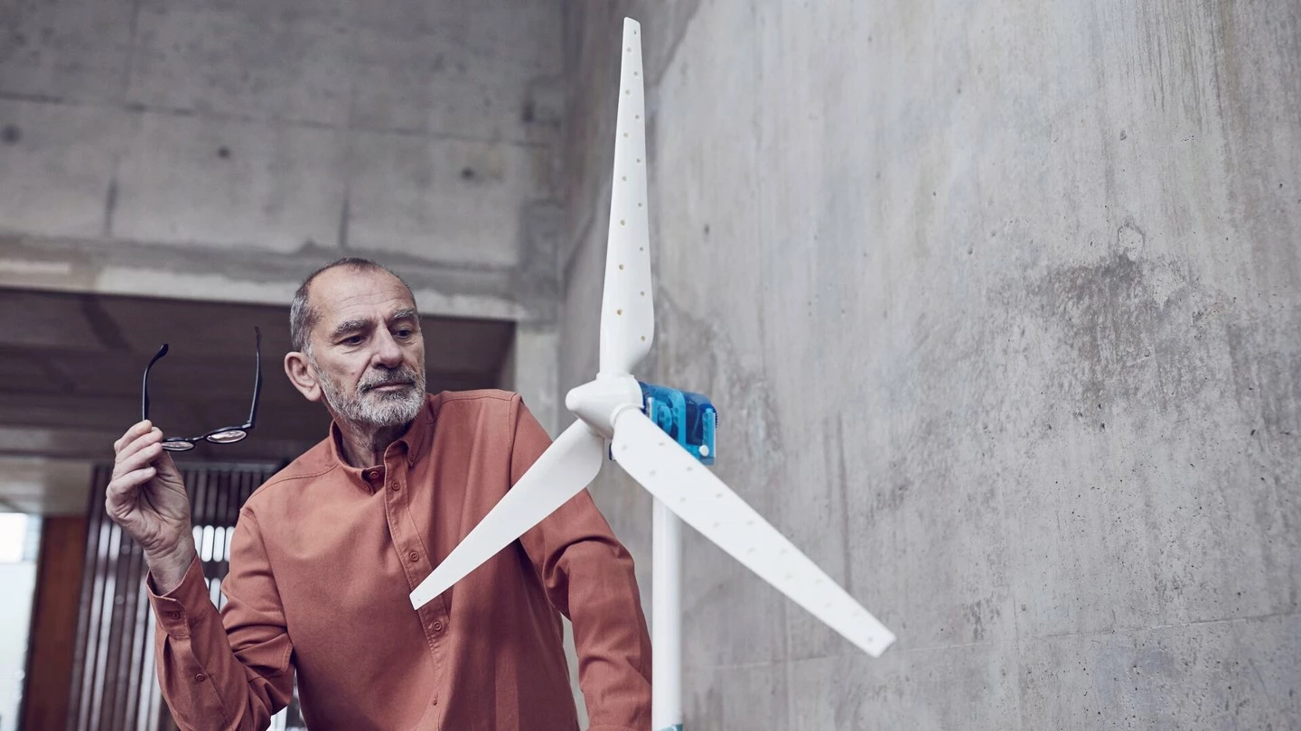 Senior man looking at prototype of wind turbine 