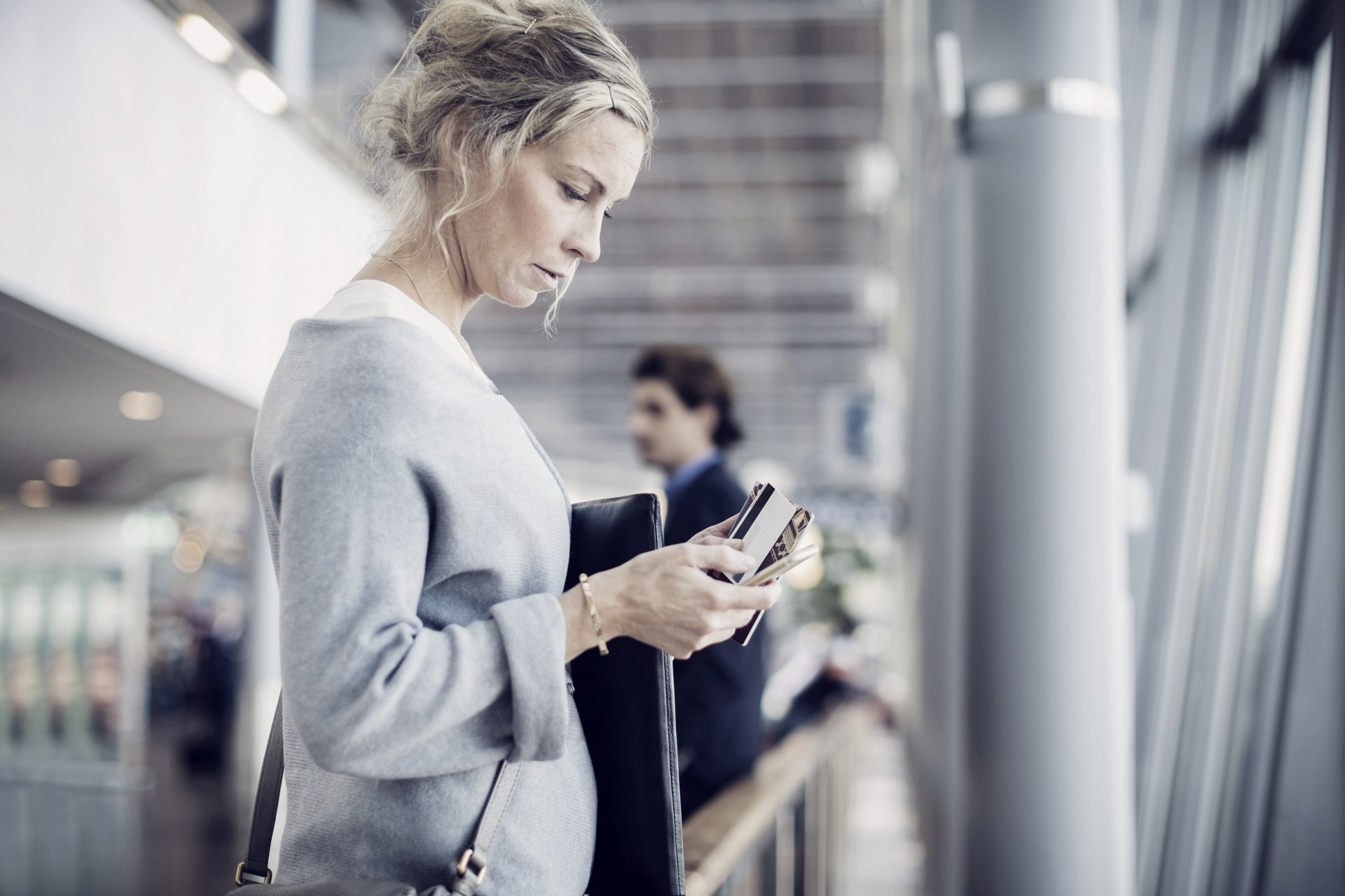 Side view of woman using phone at airport