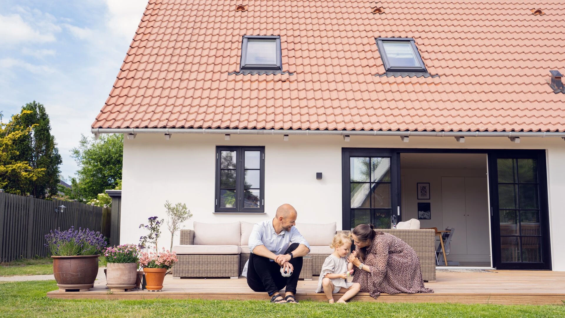 Parents and child in front of house
