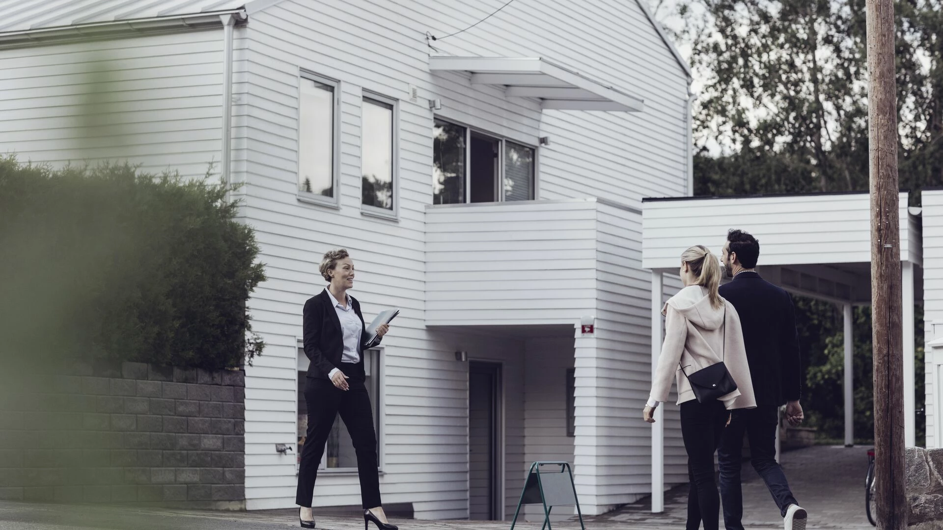 Smiling real estate professional talking to couple