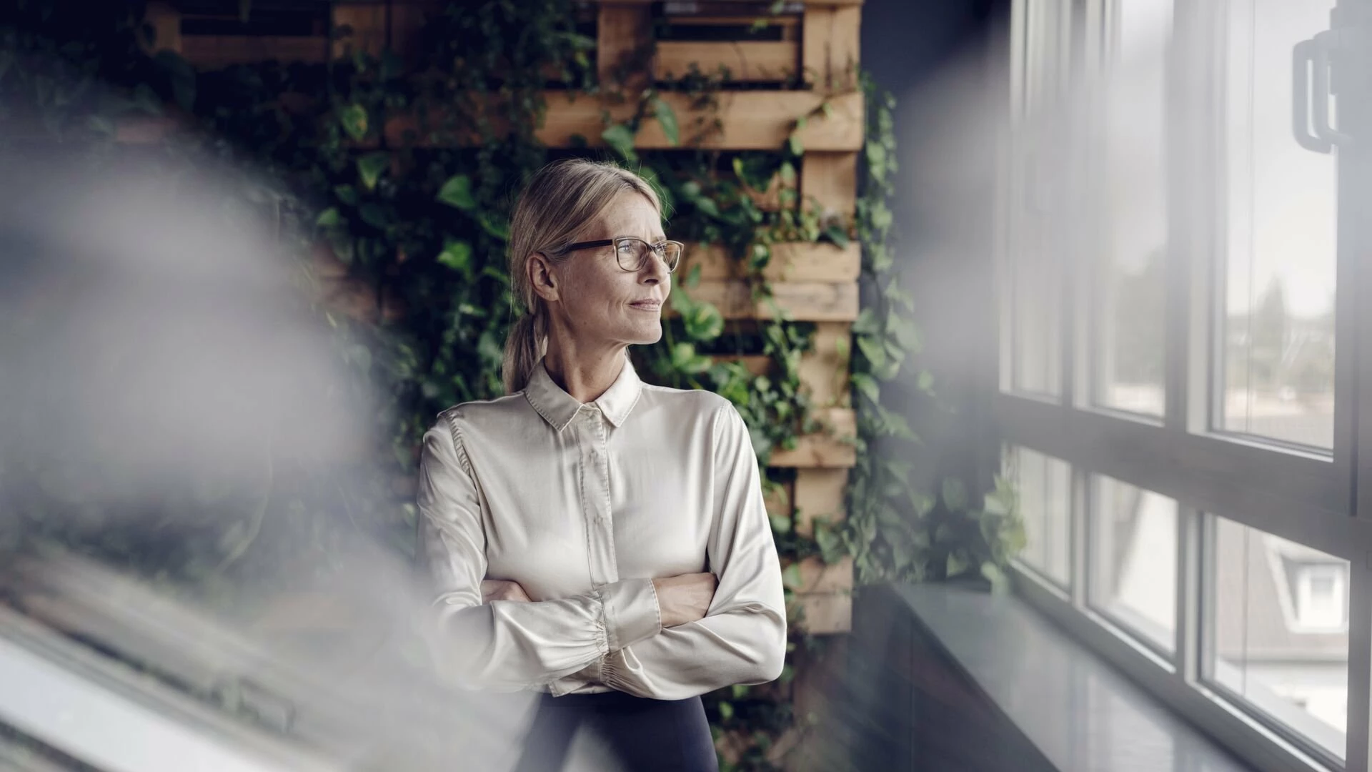 Businesswoman in green office looking out of window1920x1080.jpg