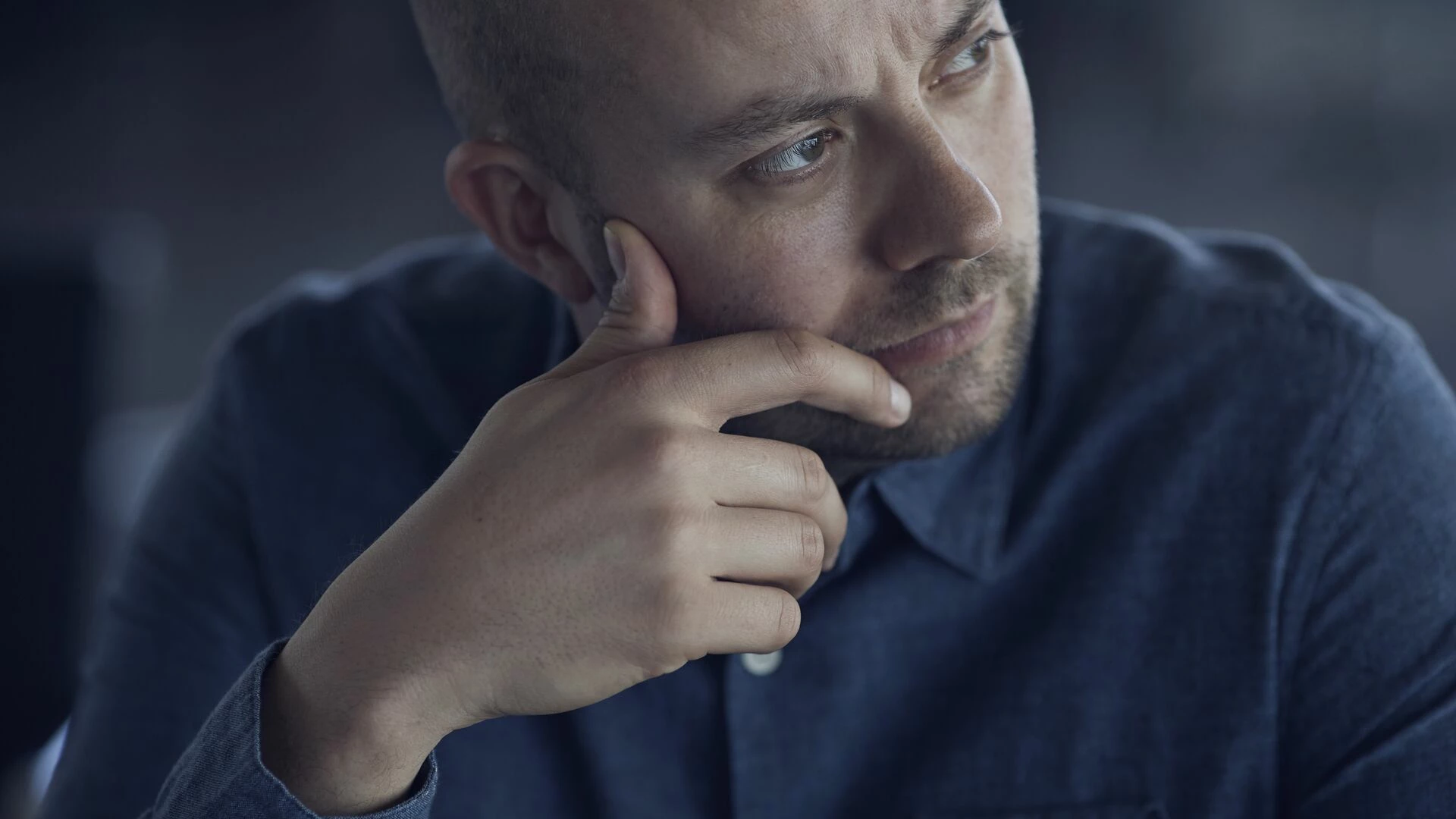 Businessman sitting in conference room, looking thoughtful