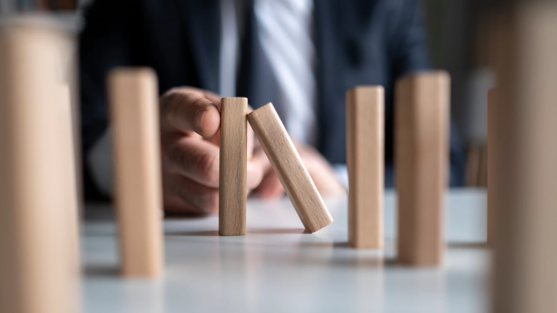 man stopping domino effect