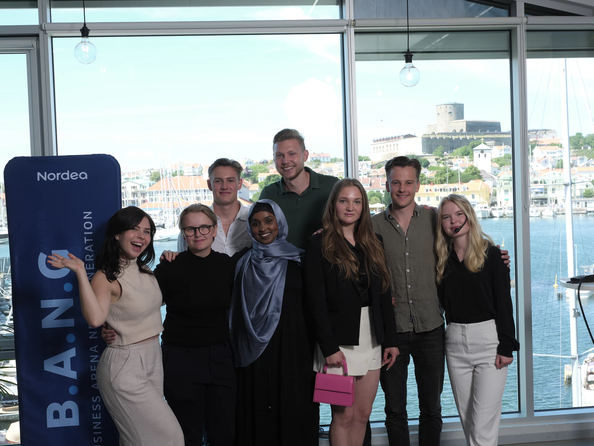 Picture of young adults standing in front of a window.