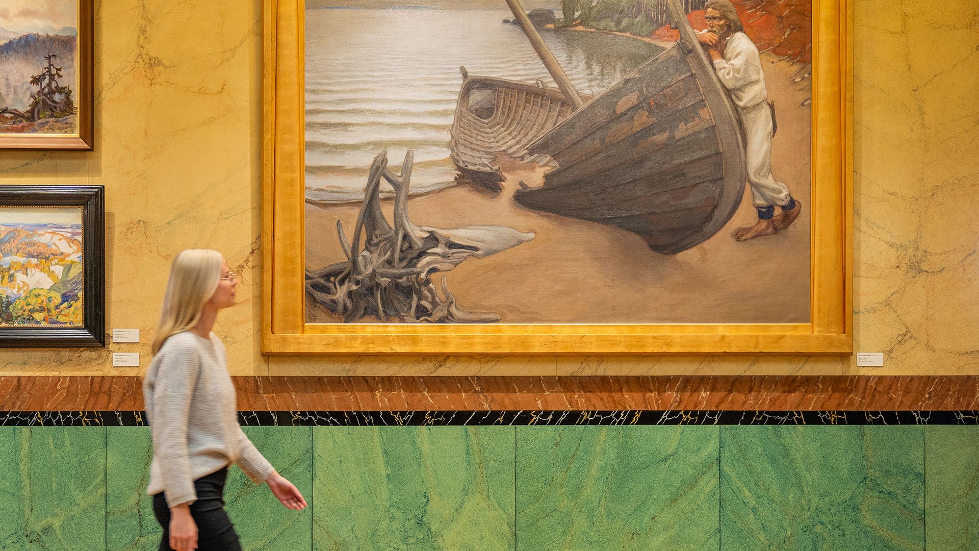 A woman walking by a painting at an art gallery.