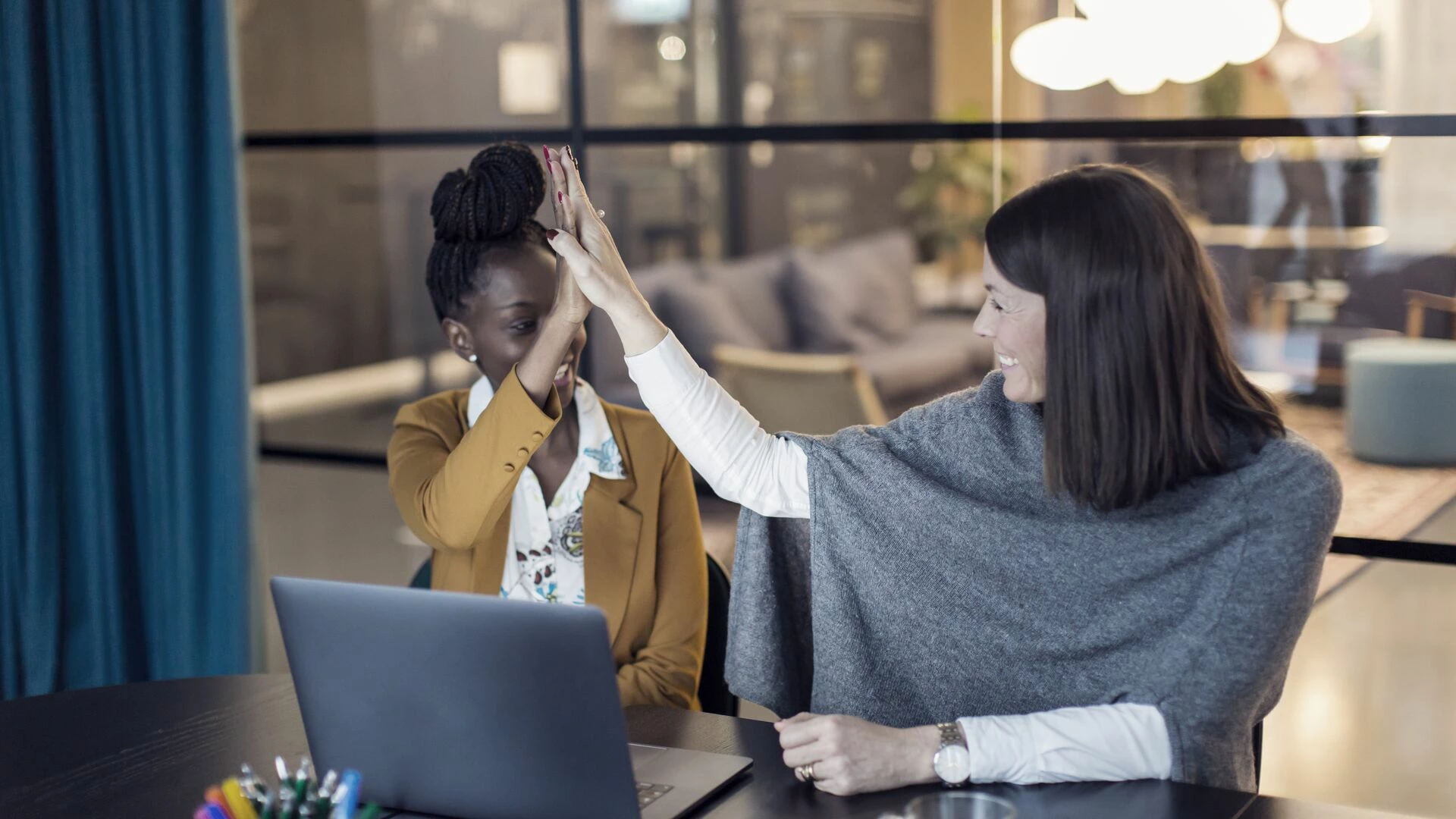 Co-workers using laptop in boardroom