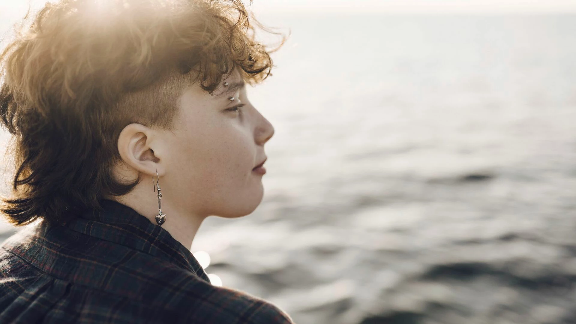 Teenage with piercing looking at sea