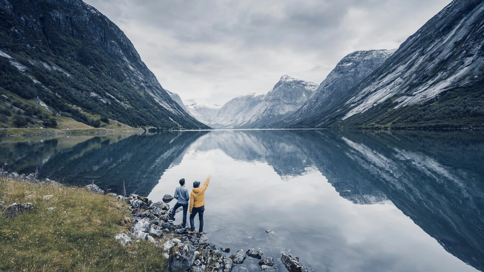 Friends admiring the view on the banks of a Norwegian fjord