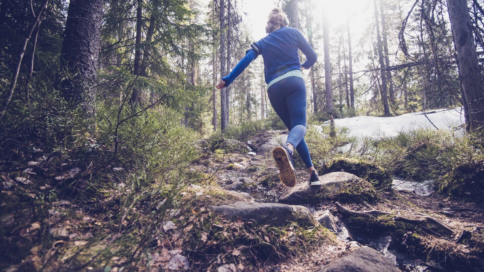 Woman trail runner running in forest