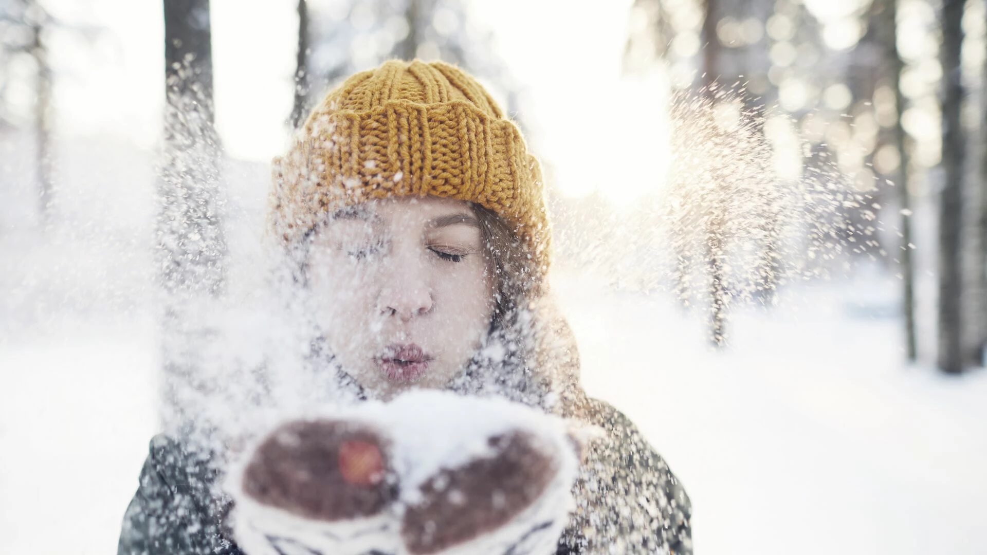Tjej blåser snö mot kameran
