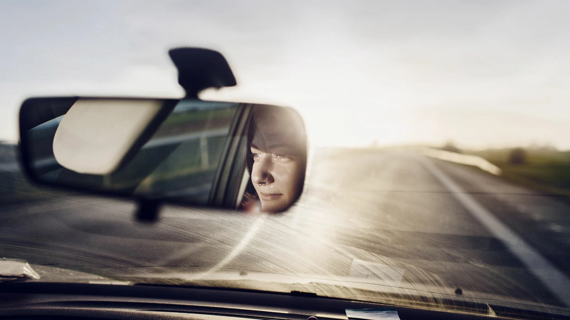 Reflection of a woman in rear view mirror