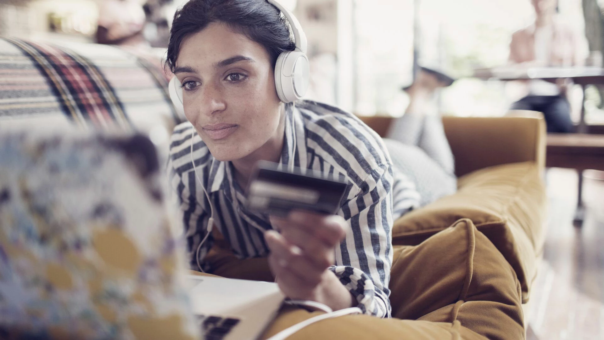 Woman online shopping from her sofa