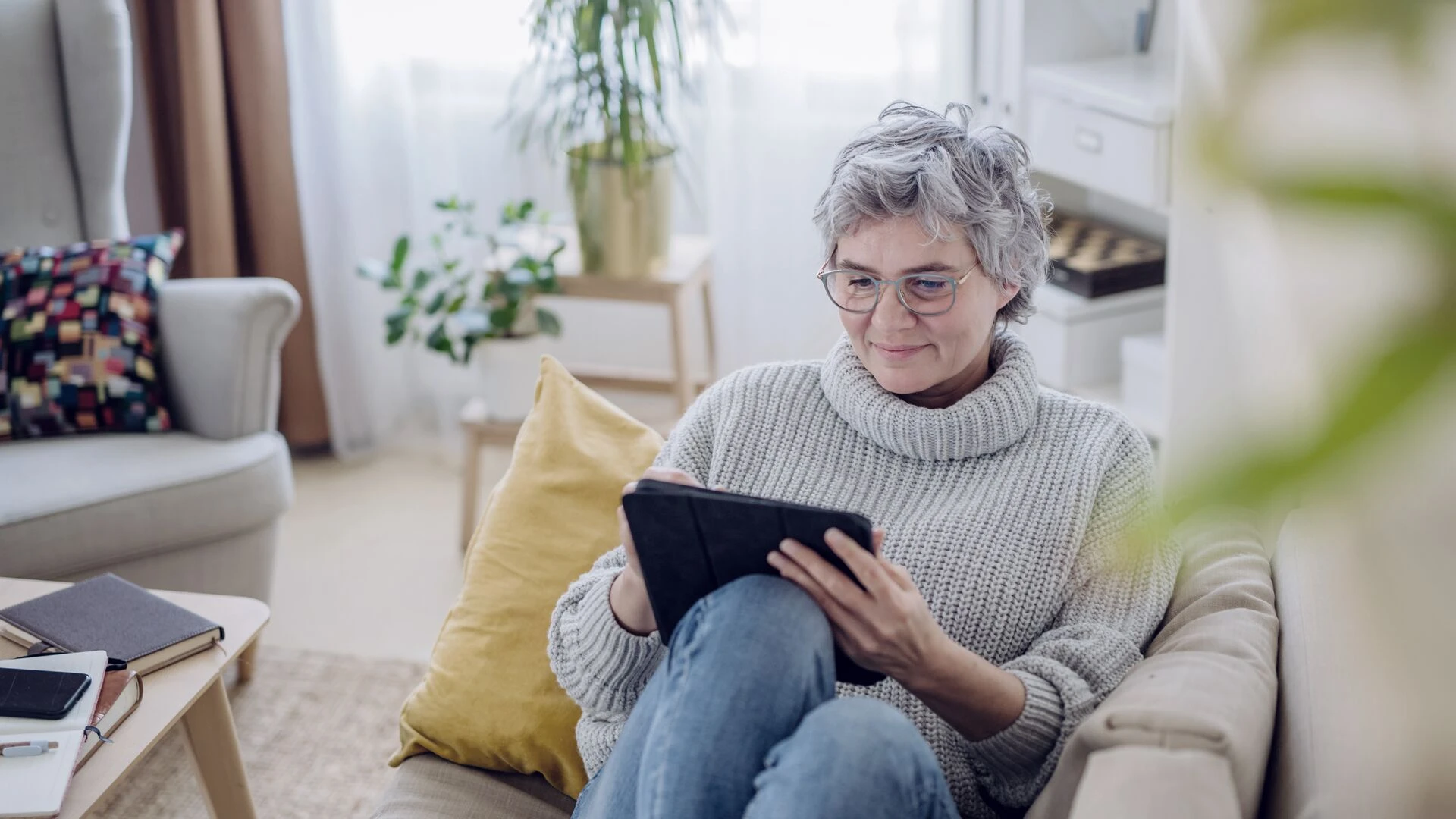 Person sitting on a sofa and using a tablet