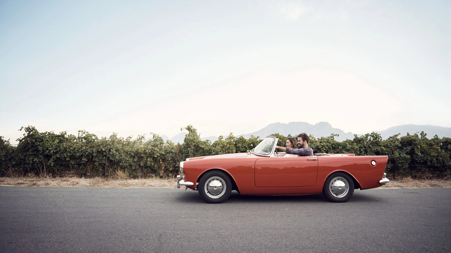 Couple driving in an old convertible car