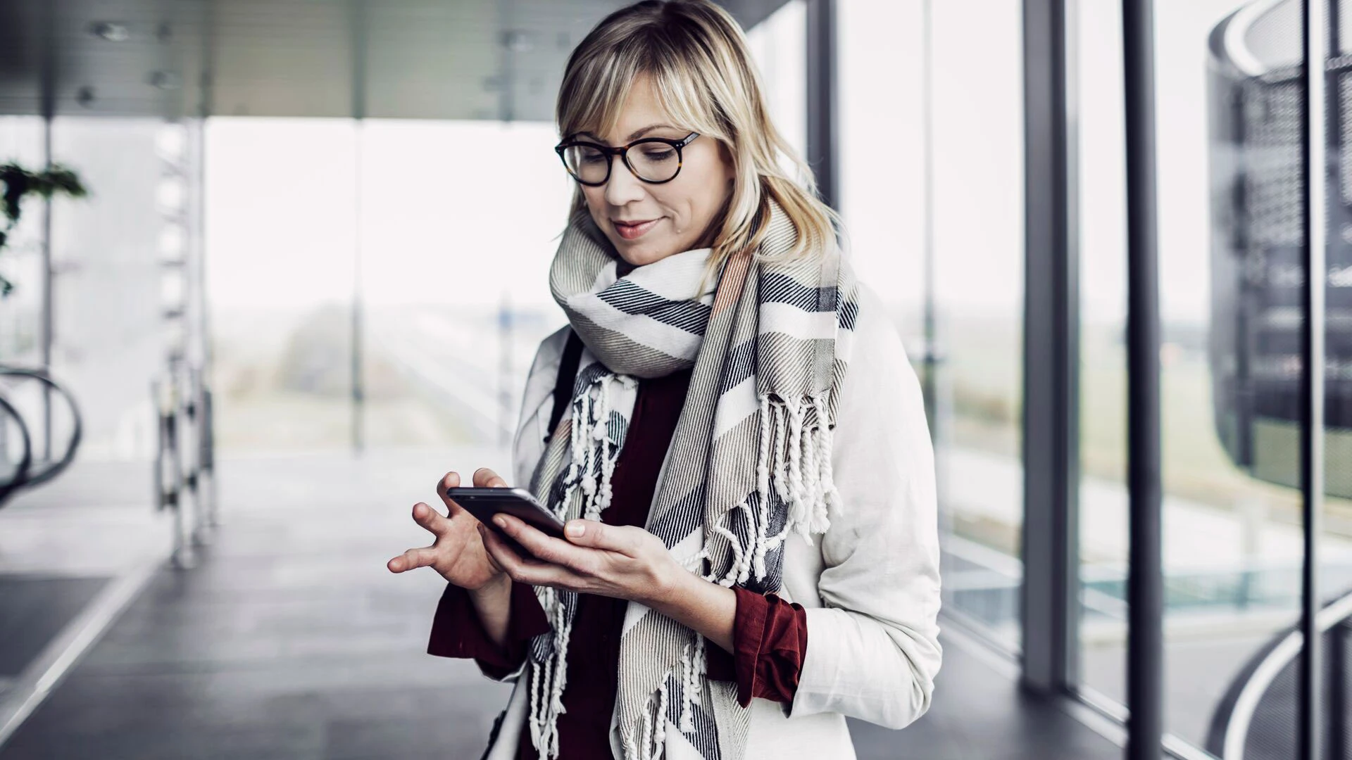Businesswoman with smart phone standing at the airport