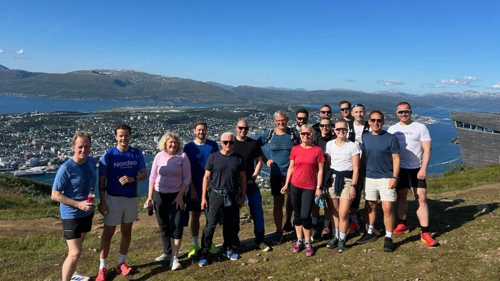 Group of people standing on top of a mountain in Norway.