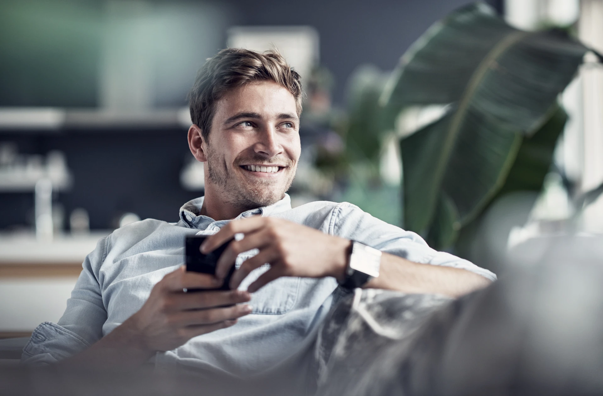 Man sitting in couch with phone