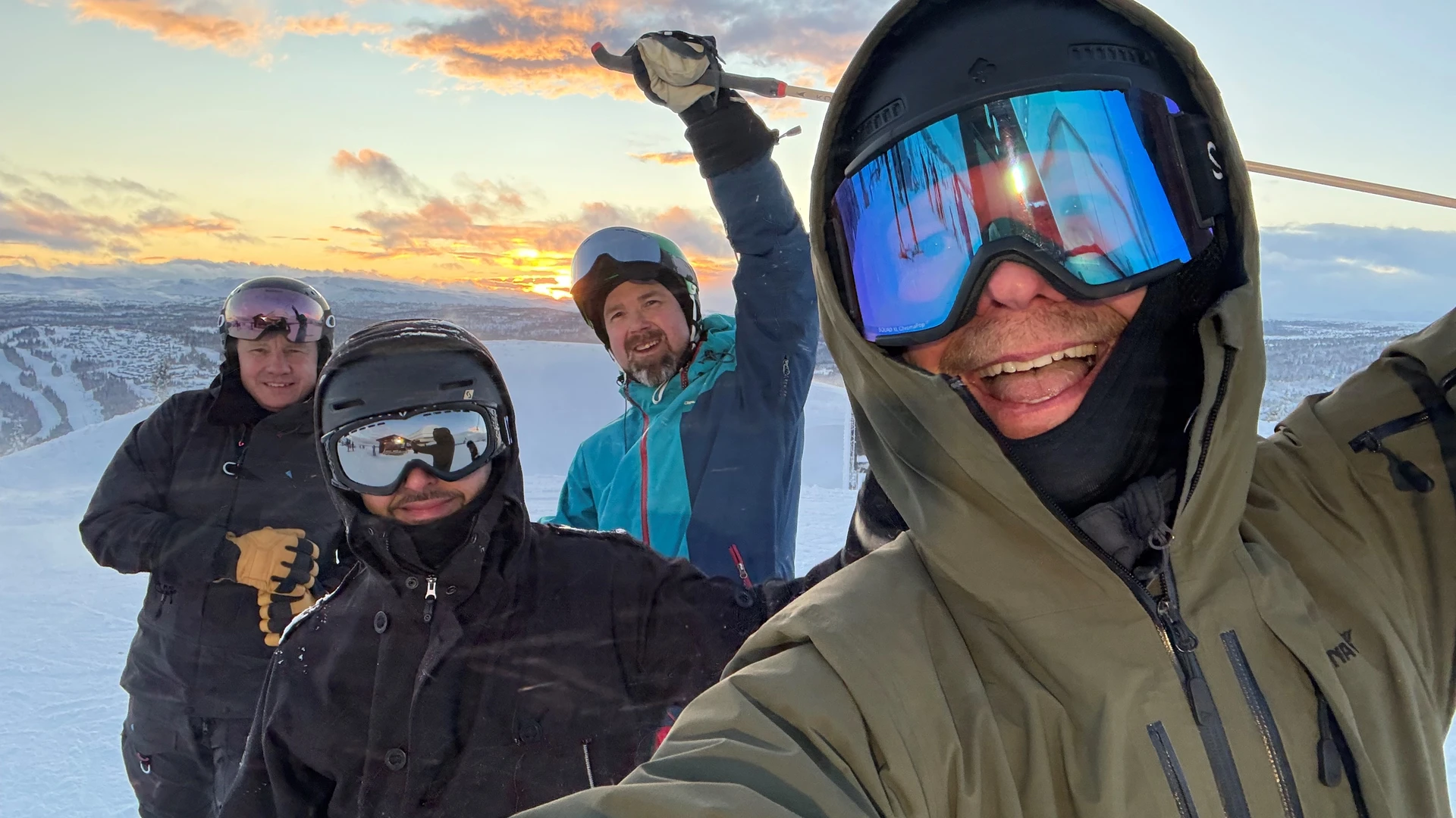 Four guys on a mountain with skis