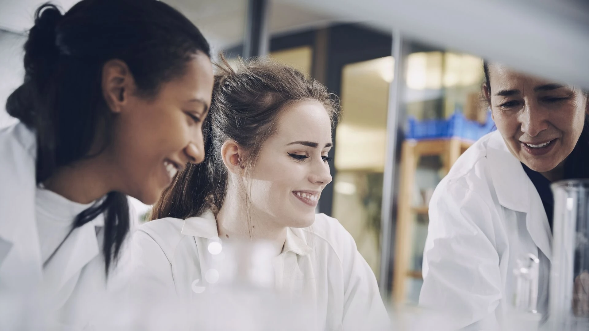 Mature teacher with young female students in the lab