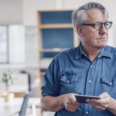 Senior man holding tablet 