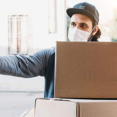 Delivery man is ringing the bell to deliver two cardboard boxes