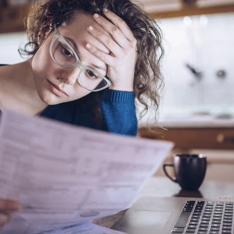 Woman going through bills, looking worried