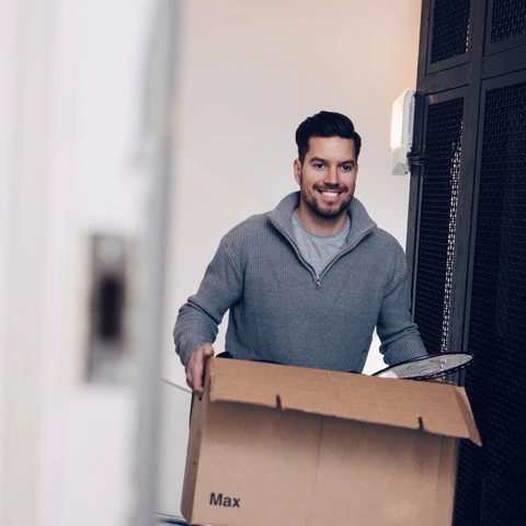 Young man carrying moving box