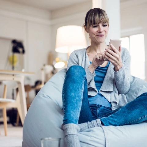 Relaxed woman using phone