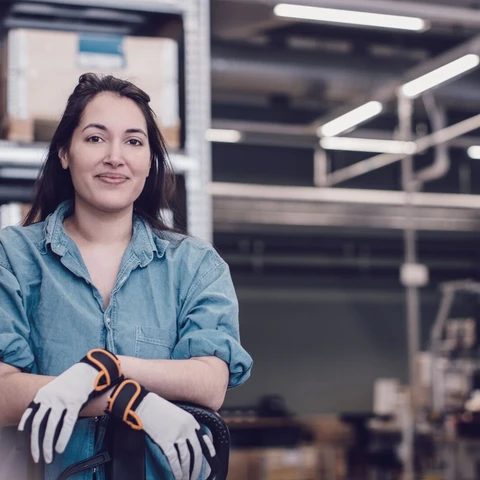 Young worker leaning on pallet jack at warehouse